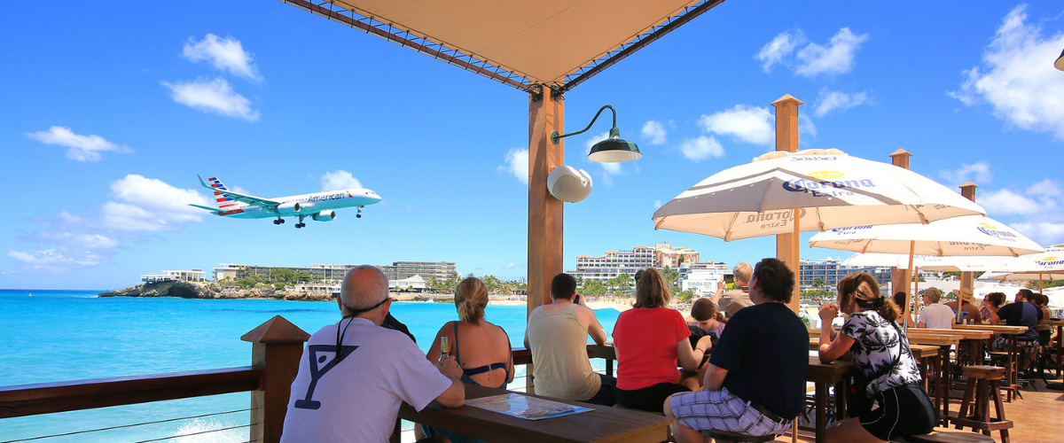 Sunset Beach Bar in St. Martin with views of the ocean and an airplane coming in for landing over the water