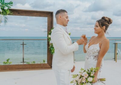 couple toasting with a shot of tequila, smiling at each other during their destination wedding.