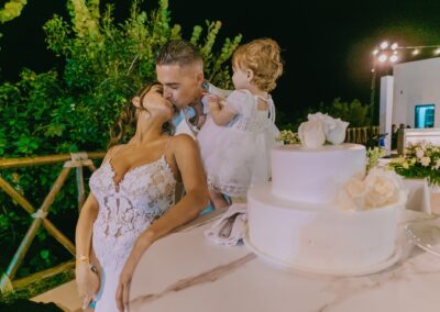 wedding couple and child at their wedding reception, everyone wearing white.