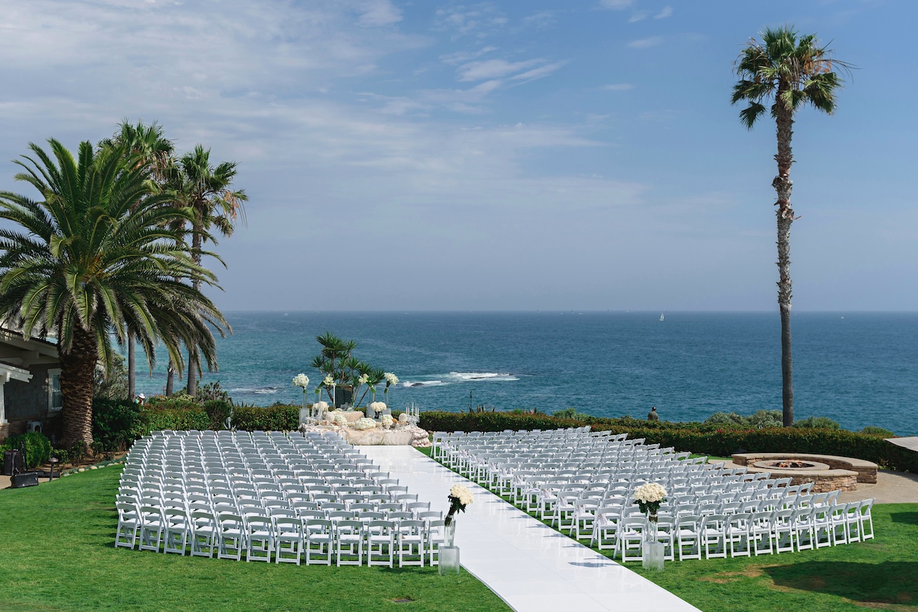 Punta Cana destination wedding venue Destination wedding set up with lots of white chairs and flowers, with beach as the backdrop in Punta Cana, Dominican Republic, blue skies and ocean.