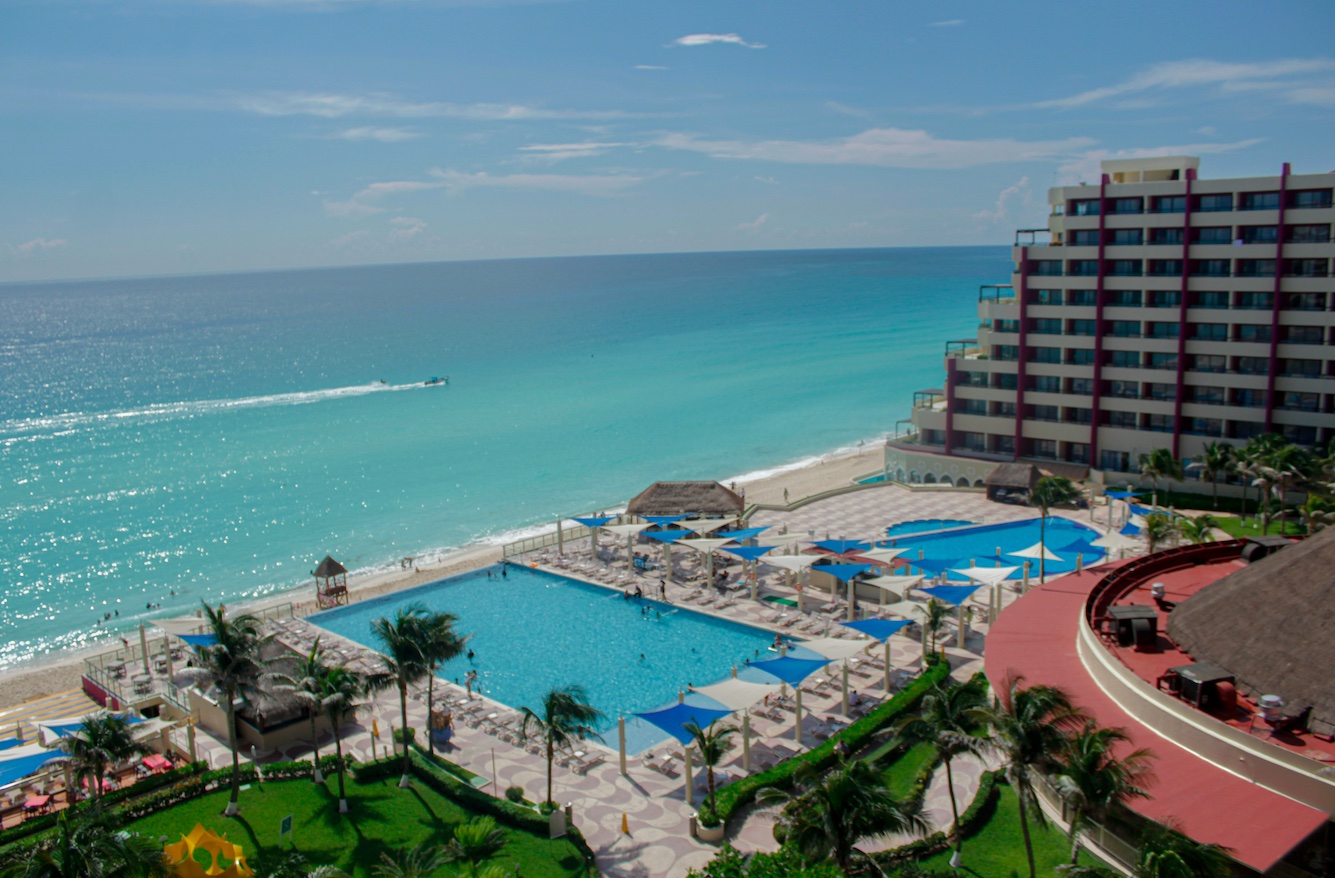 Zona Hotellera Cancun bird's eye view of a beach resort in the Cancun Hotel Zone. Turquoise waters and pools by the Caribbean Sea.